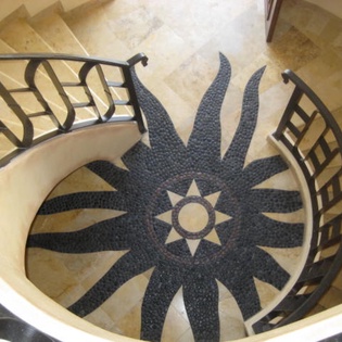 An elegant spiral staircase adorned with intricate mosaic tilework and wrought-iron railings creates a stunning architectural centerpiece, adding character and sophistication to your vacation retreat.