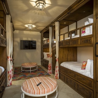 Your private dormitory-style retreat features elegant carved bunk beds with privacy curtains, creating cozy spaces for restful nights.