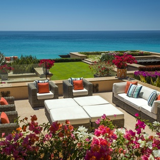 Your private oceanfront terrace showcases stunning sea views while you relax on plush outdoor furniture surrounded by vibrant tropical blooms.