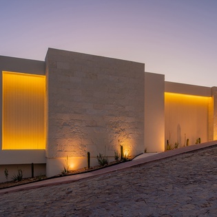 Modern architectural design with warm evening lighting creates a striking arrival experience at this contemporary property.