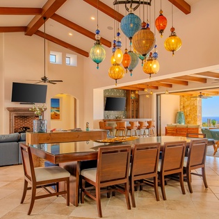Gather around your stunning dining table beneath artisan pendant lights, with ocean views flowing through open walls.