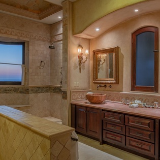 Unwind in this opulent bathroom featuring dual vessel sinks, a soaking tub, and mountain views through your private window.