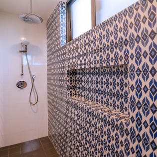Step into your stylish walk-in shower featuring stunning geometric tilework and modern fixtures for a refreshing start to your day.