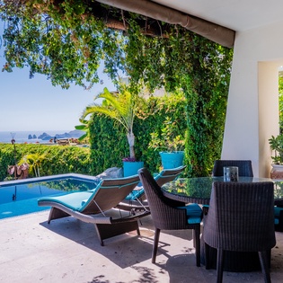 Poolside patio with shady seating area and ocean views