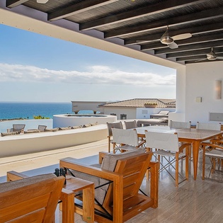 A view of the ocean and surrounding area from a covered outdoor dining terrace at the property.