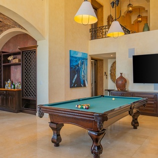 Your private game room awaits with a stunning pool table, wet bar, and flat-screen TV in elegant surroundings.
