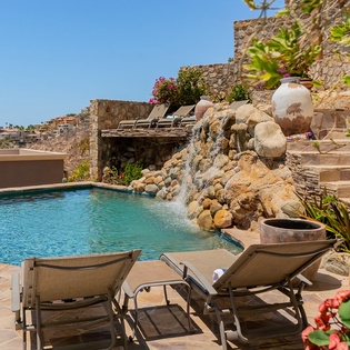 Stone patio with sun deck and pool