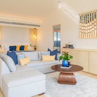 Sink into this plush sectional sofa surrounded by warm wood tones and modern coastal elegance, where navy and gold accents create your perfect retreat.