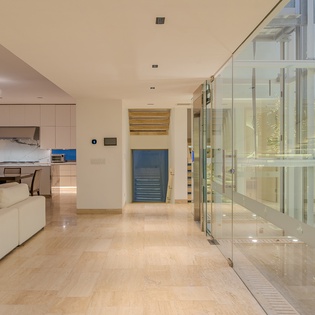 Step into your luxurious modern sanctuary where sleek glass elevators and polished floors create an atmosphere of sophisticated comfort.