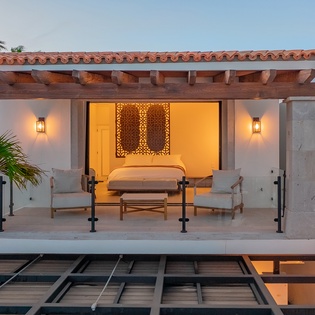 Your elegant suite opens to a private terrace with seating area, where warm lighting and refined décor create an intimate escape.