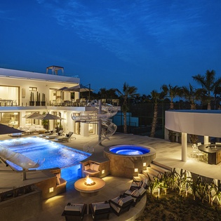Patio view of pool and jacuzzi at night