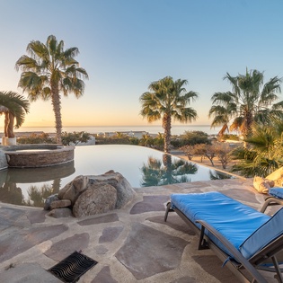 Infinity pool and jacuzzi with ocean views during sunset