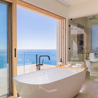 En suite bathroom with bath tub and ocean views