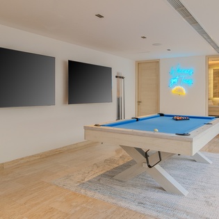 Challenge friends to pool in your stylish game room, complete with twin TVs and vibrant neon art.