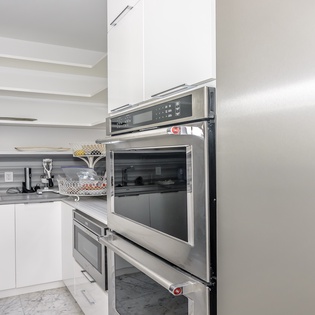 Your sleek modern kitchen features top-tier stainless appliances and pristine white cabinetry, creating the perfect space for culinary adventures.