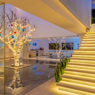 Step into a stunning modern lobby where warm LED lighting creates an enchanting ambiance around the artistic centerpiece tree.