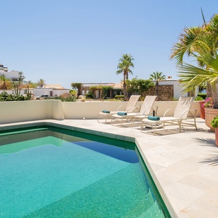 Poolside view with lounge chairs and ocean view