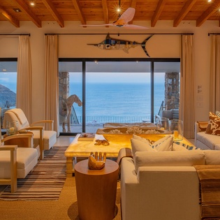Unwind in your elegant living space with stunning ocean views stretching to the horizon from floor-to-ceiling windows.