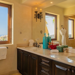 Unwind in your spa-like bathroom with dual vanities, plush robes, and stunning ocean views that transform your daily routine into pure luxury.