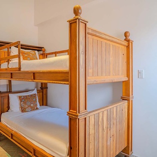 Cozy wooden bunk beds with fresh linens await you—perfect for kids or groups traveling together, blending charm with space-saving comfort.