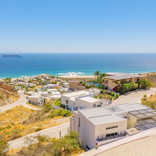 Stunning aerial view of the coastal community showcasing beautiful beachfront location with crystal-clear turquoise waters and pristine sandy shore.
