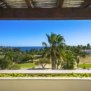 Breathtaking ocean and golf course views stretch across tropical landscape from this elevated terrace.