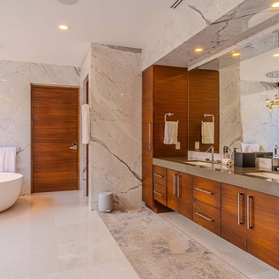 Step into your luxurious spa-like bathroom, where elegant marble walls meet rich wood cabinetry. Soak in the freestanding tub or refresh under the rain shower—your personal oasis awaits.