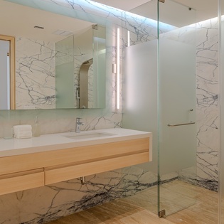 Step into your spa-like ensuite with stunning marble walls and sleek glass shower—pure luxury awaits.