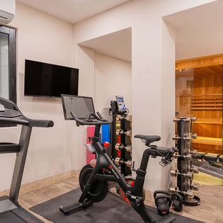 Your private fitness area features modern cardio equipment and strength training options, with a sauna right next door to complete your workout routine. Cool off comfortably with dedicated climate control.