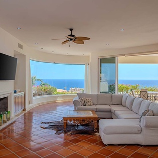 Unwind in this bright and spacious living room where sweeping ocean views create your perfect backdrop. Sink into plush seating, enjoy the warm terracotta floors, and step outside to take in the endless blue horizon stretching before you.