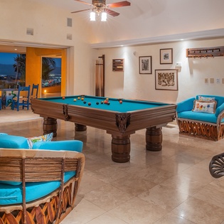 Unwind in your private game room with pool table, cozy seating, and stunning twilight views through expansive windows.