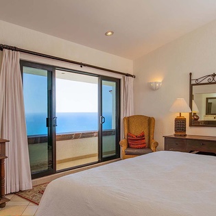 Wake up to breathtaking ocean views through your private balcony doors. Soft linens and warm wood furnishings create your serene coastal retreat.
