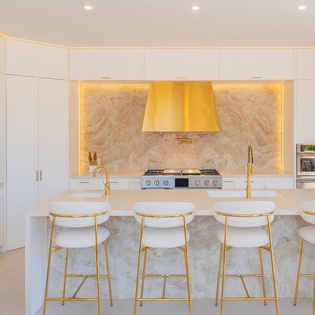 Your sleek kitchen awaits with marble counters, gold accents, and everything needed to craft memorable meals together.