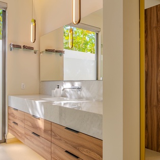 Step into your sleek ensuite with floating double vanities, where warm wood meets marble beneath modern pendant lights.