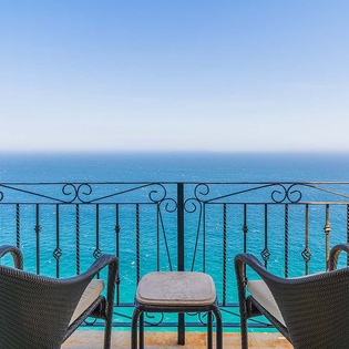 Azure waters stretch endlessly before you from this private balcony perch. Settle into woven chairs with your morning coffee as gentle sea breezes invite pure relaxation.