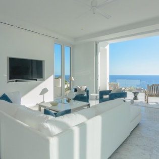 Unwind in your bright living space where ocean breezes flow through floor-to-ceiling windows, revealing endless sea views from your private terrace.