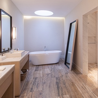 En suite bathroom with bath tub and double sink