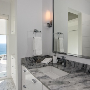 Your private bathroom features elegant marble countertops and stunning sea views from the window.