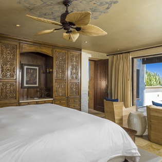 Wake up to breathtaking ocean views from your luxurious bedroom, where handcrafted furnishings and tropical ceiling fans create the perfect seaside sanctuary.