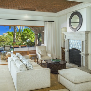 Relax in your elegant living room where tropical ocean views meet sophisticated comfort, complete with cozy fireplace for perfect evenings.