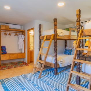 Your kids will love this charming bunk room with handcrafted wooden beds, cozy linens, and thoughtful storage for all their treasures.