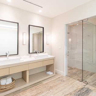 En sutie bathroom with double sink with walk in shower