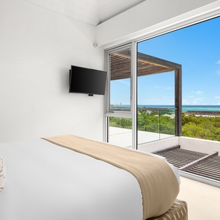 Wake up to stunning ocean views from your private bedroom, where floor-to-ceiling windows frame endless blue horizons and tropical beauty.