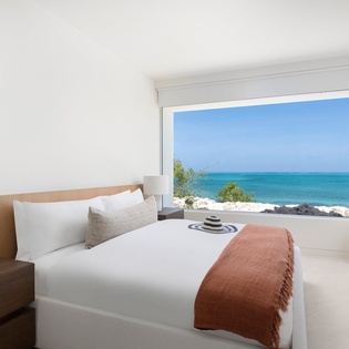 Wake up to pristine turquoise waters stretching to the horizon from your serene bedroom sanctuary.