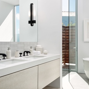 Soak in your luxurious spa-like bathroom featuring a sleek soaking tub, modern dual vanity, and stunning natural light flooding through floor-to-ceiling windows.