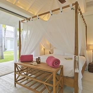 Wake up in your dreamy four-poster bed surrounded by flowing white curtains, with tropical views greeting you each morning.