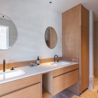 Unwind in your spa-like bathroom with double vanities and warm wood accents for a peaceful morning routine.