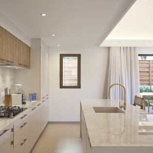 Your sleek modern kitchen features gleaming countertops, premium appliances, and warm wood accents, perfect for preparing memorable meals.