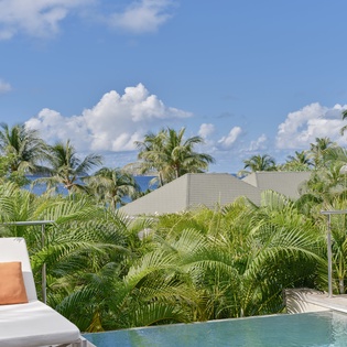 Relax poolside surrounded by swaying palms and endless blue skies in your own tropical paradise.