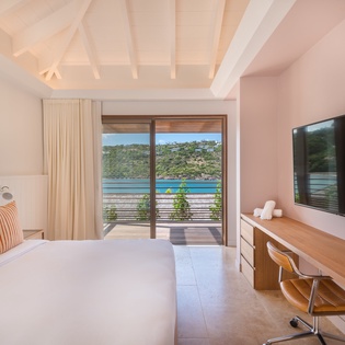 Wake up to breathtaking ocean views from your luxurious bed, where exposed beams and coastal décor create the perfect seaside retreat.